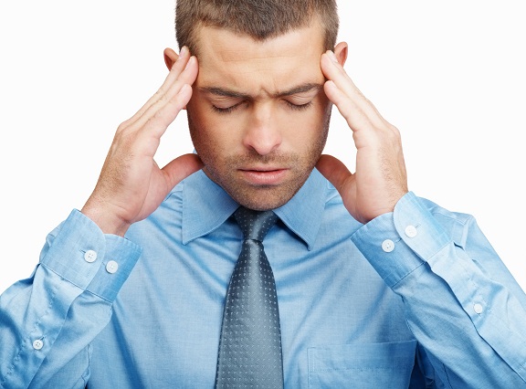 Headache - Closeup of a young business man holding head in pain isolated on white